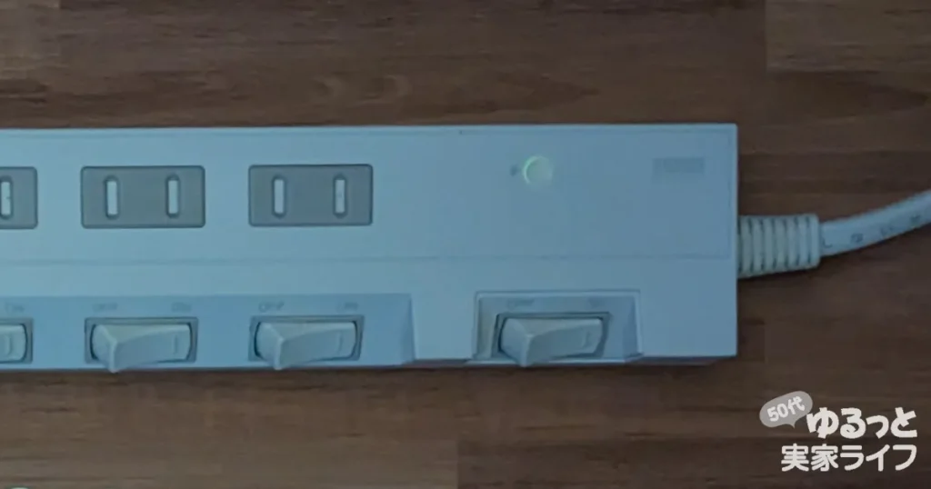 小さな明かりにシルバーの遮光シールを貼った電源タップの写真